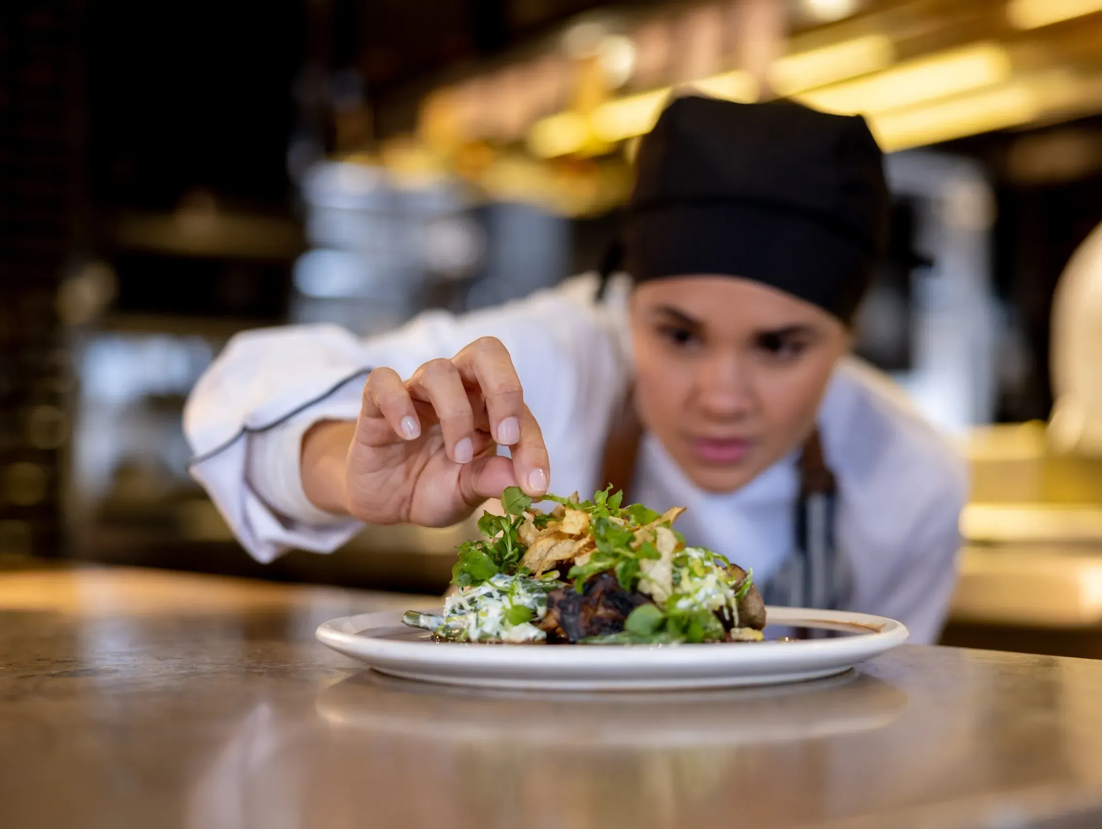 Chef finalizando um prato com brotos e microverdes